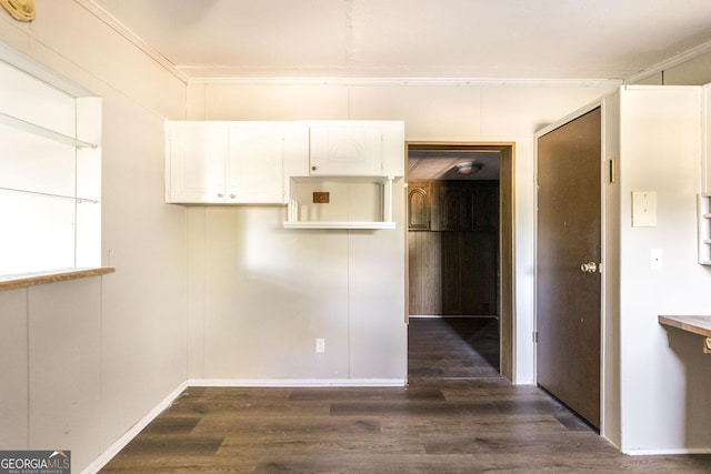 kitchen with white cabinetry, crown molding, and dark wood-type flooring