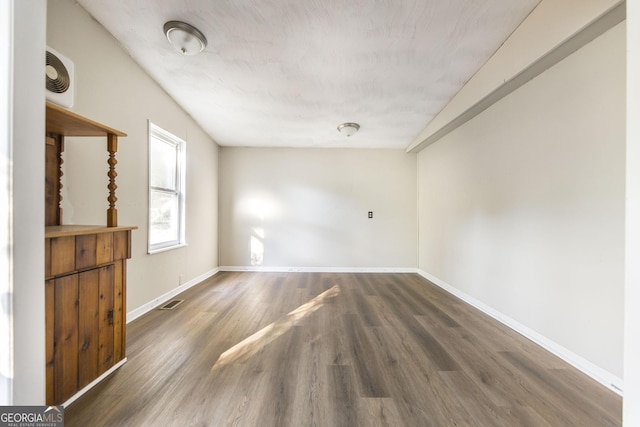 spare room with dark wood-type flooring