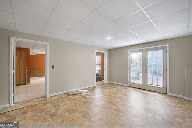 spare room featuring french doors and a drop ceiling