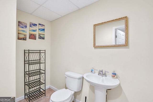 bathroom featuring toilet, tile patterned floors, a paneled ceiling, and sink