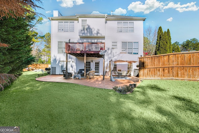 rear view of house with a patio area and a lawn