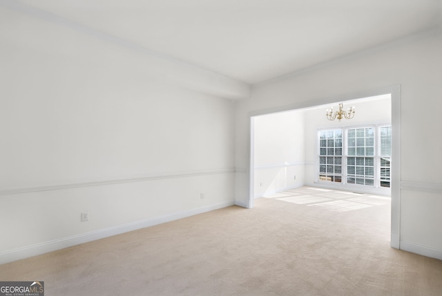 carpeted empty room with a chandelier