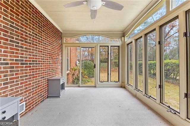 unfurnished sunroom featuring ceiling fan