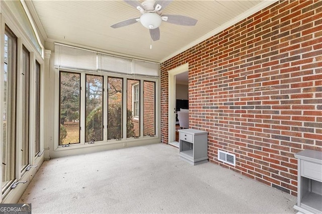 unfurnished sunroom featuring ceiling fan