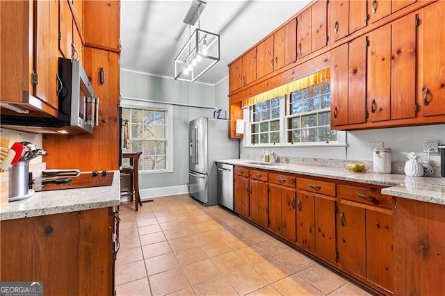 kitchen featuring pendant lighting, sink, light stone countertops, light tile patterned floors, and stainless steel appliances