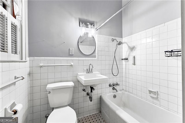 full bathroom featuring sink, tile patterned flooring, toilet, tile walls, and tiled shower / bath