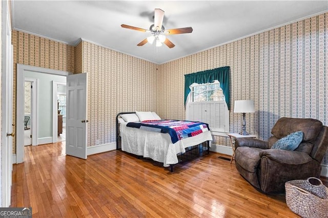 bedroom featuring wood-type flooring, ceiling fan, and crown molding