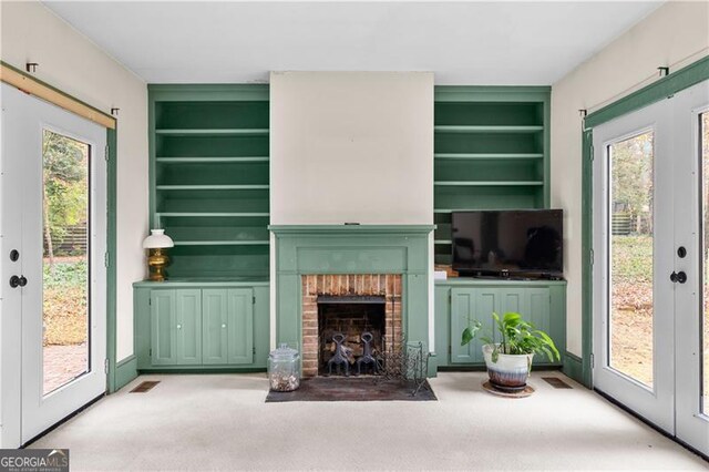 carpeted living room featuring built in features and a brick fireplace