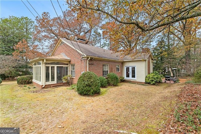 rear view of property with a sunroom and french doors