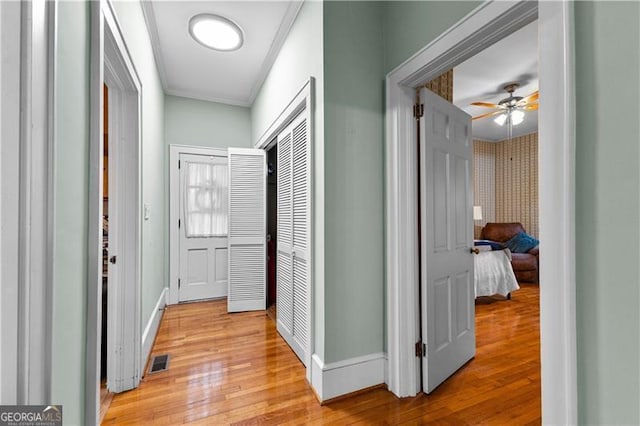 hallway featuring hardwood / wood-style floors and ornamental molding