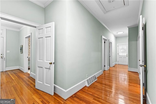 corridor with hardwood / wood-style floors and crown molding