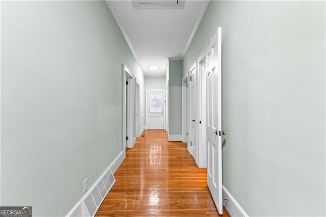 hallway featuring light wood-type flooring and crown molding