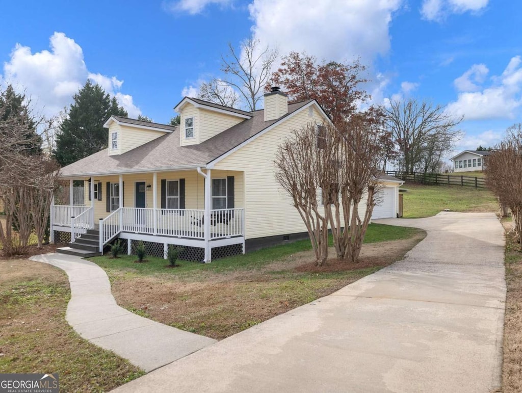 view of front facade with a front lawn, covered porch, an outdoor structure, and a garage