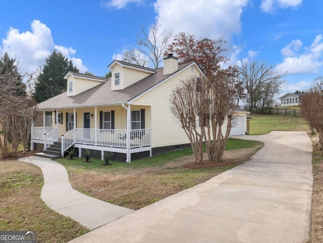 view of front facade with a front lawn, covered porch, an outdoor structure, and a garage