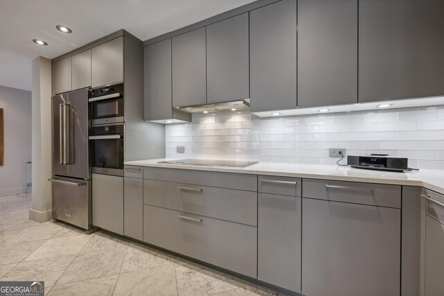 kitchen featuring gray cabinetry, backsplash, and appliances with stainless steel finishes