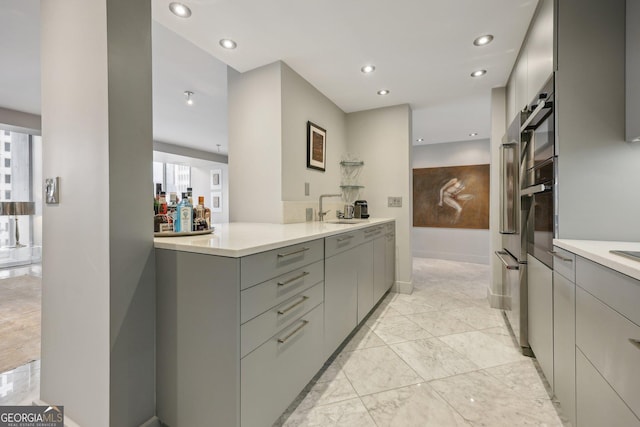 kitchen with gray cabinets, sink, and oven