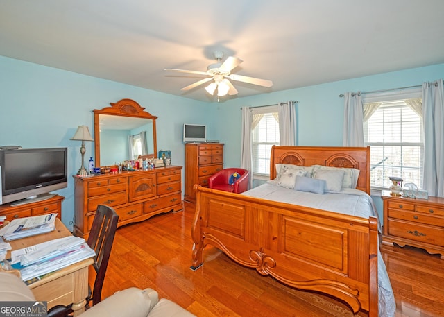 bedroom featuring multiple windows, ceiling fan, and light wood-type flooring