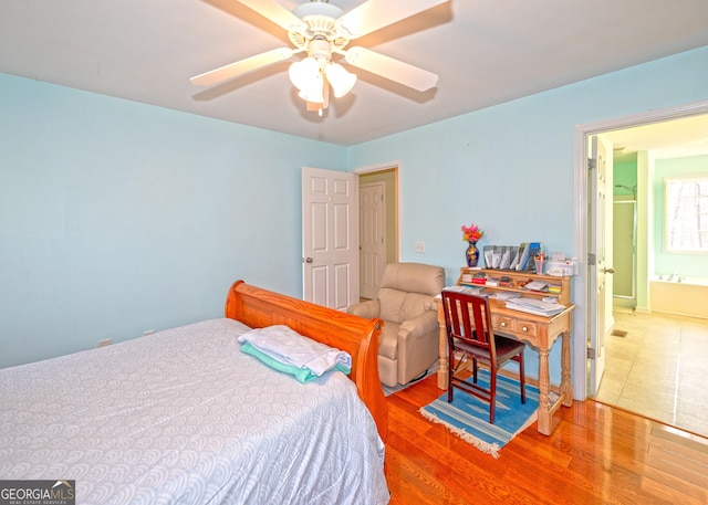 bedroom featuring hardwood / wood-style floors, ensuite bathroom, and ceiling fan