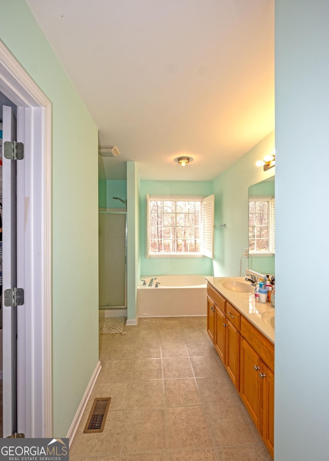 bathroom with tile patterned floors, vanity, and separate shower and tub