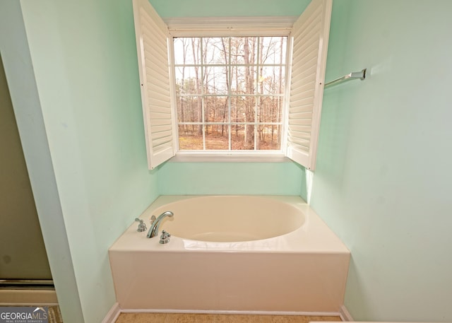 bathroom featuring plenty of natural light and a bathtub