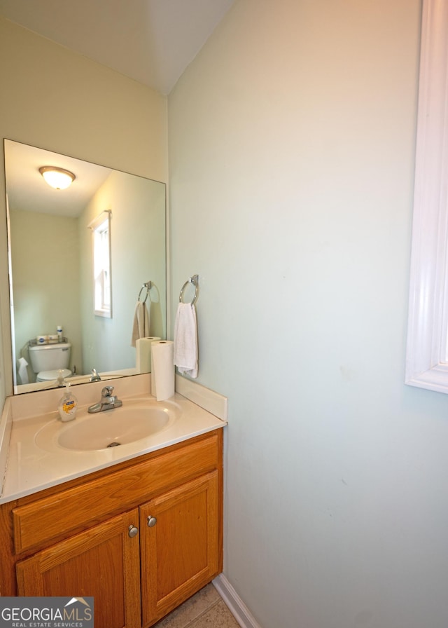 bathroom featuring tile patterned floors, vanity, and toilet