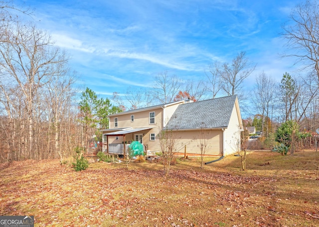 back of property featuring a lawn and a porch