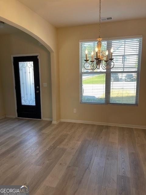 entrance foyer featuring a wealth of natural light, hardwood / wood-style floors, and a chandelier