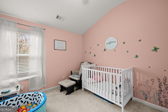 carpeted bedroom with vaulted ceiling and a crib