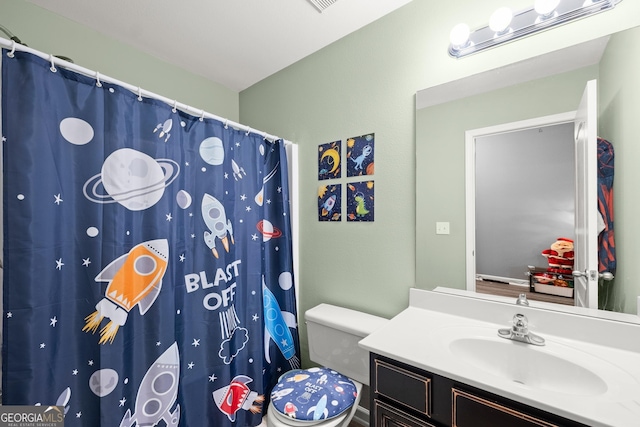 bathroom with a shower with shower curtain, vanity, and toilet