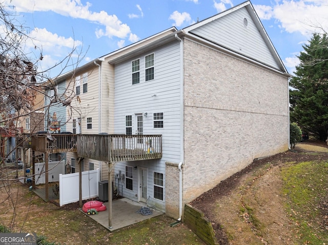 back of property featuring a deck, a patio area, and central air condition unit