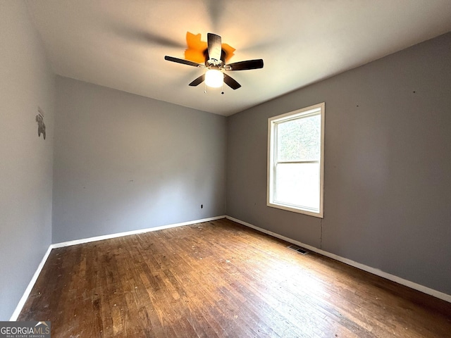 empty room with ceiling fan and hardwood / wood-style floors