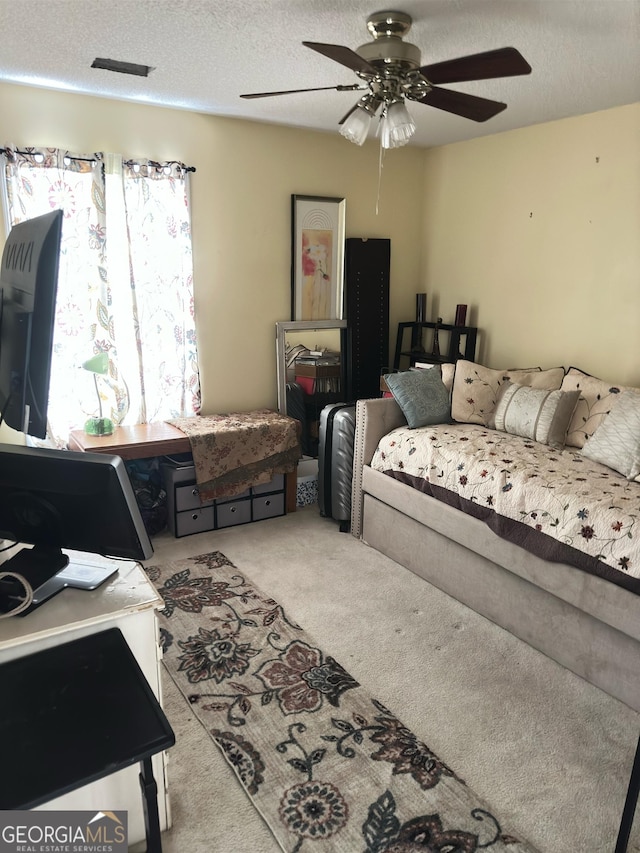 living room featuring ceiling fan, carpet flooring, and a textured ceiling