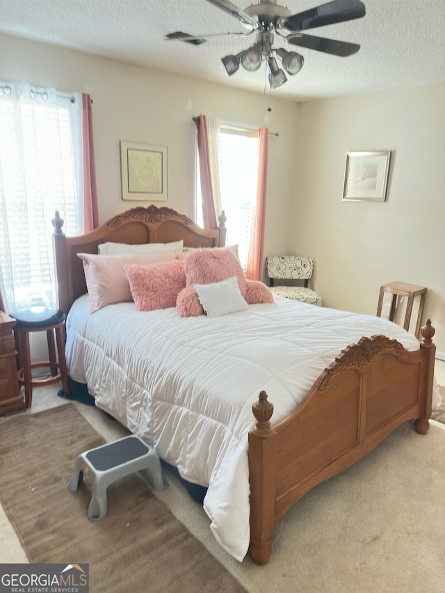 carpeted bedroom with multiple windows and ceiling fan