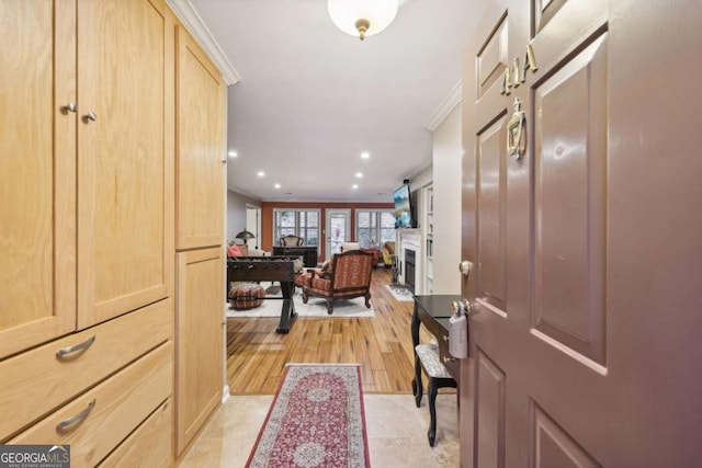 entryway with light hardwood / wood-style floors and ornamental molding