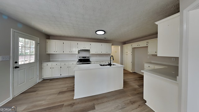 kitchen featuring electric stove, sink, a textured ceiling, light hardwood / wood-style floors, and white cabinetry