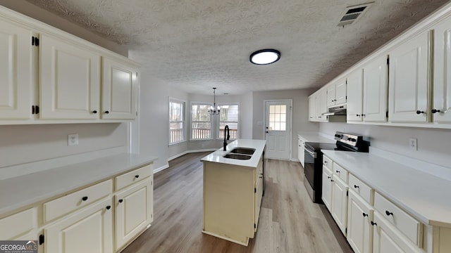 kitchen with stainless steel electric range, an inviting chandelier, light hardwood / wood-style flooring, decorative light fixtures, and a kitchen island