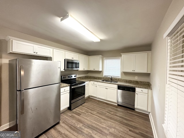 kitchen with sink, white cabinetry, dark wood-type flooring, and appliances with stainless steel finishes