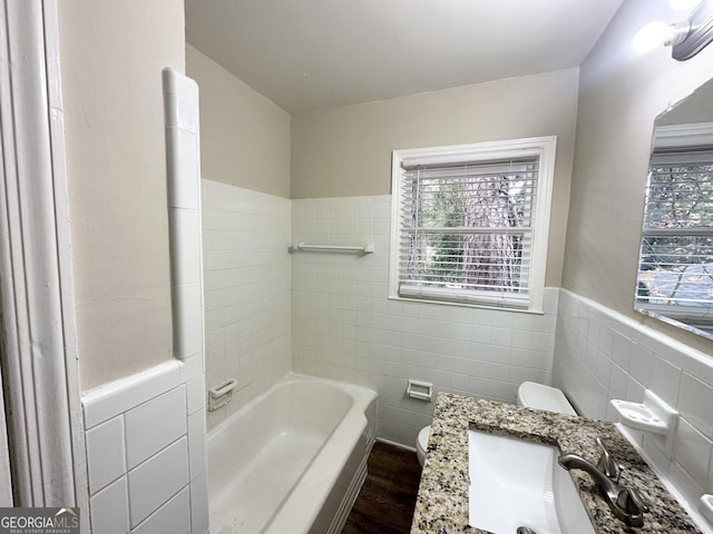 bathroom with hardwood / wood-style flooring, vanity, tile walls, and toilet