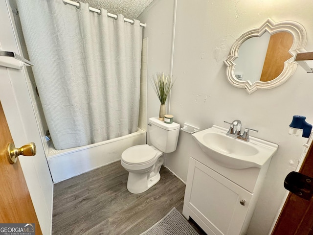 full bathroom featuring a textured ceiling, toilet, wood finished floors, vanity, and shower / bath combo