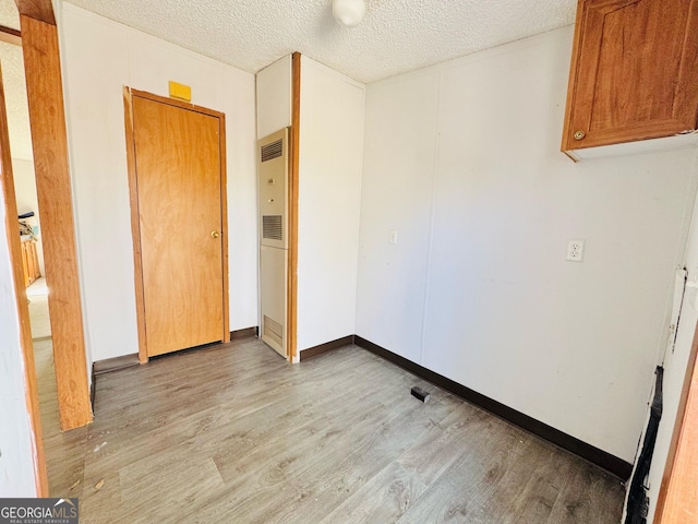 unfurnished bedroom with a textured ceiling and wood finished floors