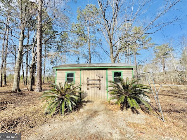 view of outdoor structure with driveway and an outbuilding