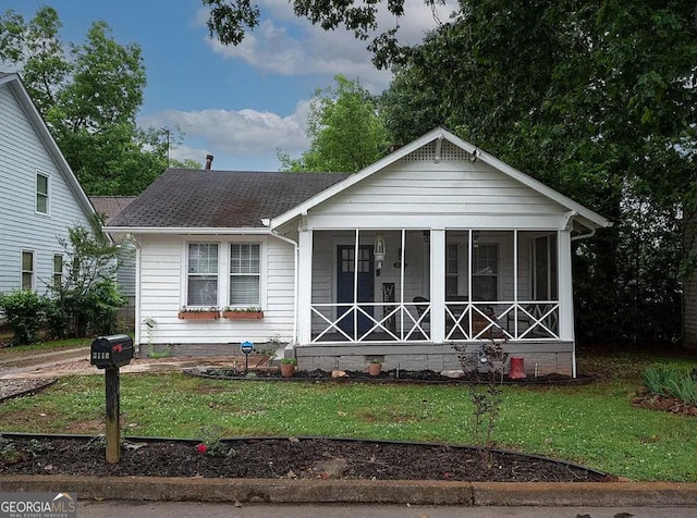 view of front of property with a front lawn and a sunroom