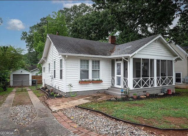 view of front of home with a garage and an outbuilding