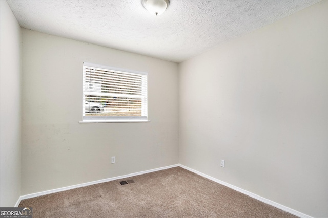 carpeted empty room with a textured ceiling