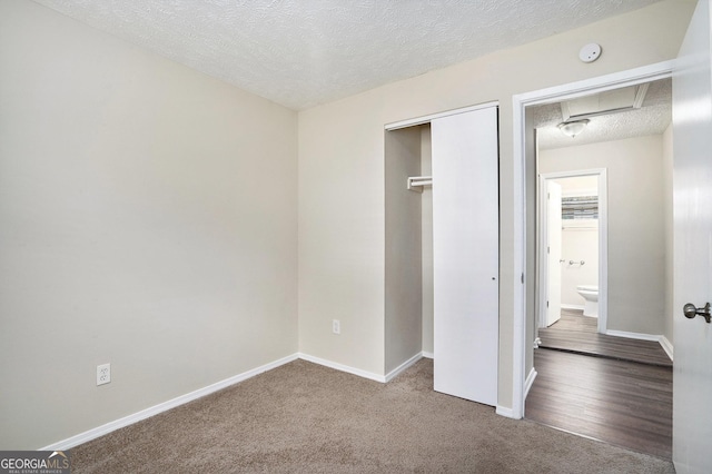 unfurnished bedroom featuring carpet flooring, a closet, and a textured ceiling