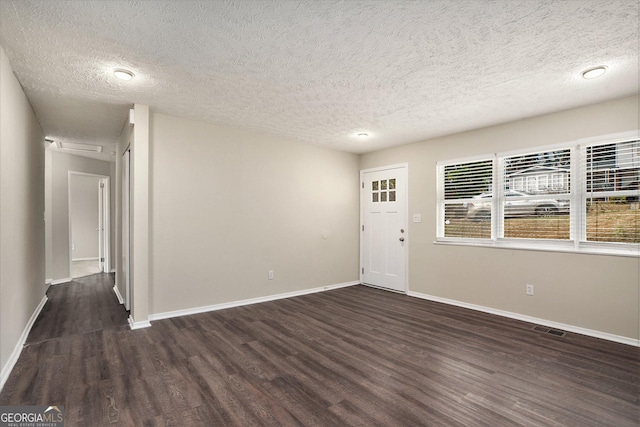 unfurnished room featuring dark hardwood / wood-style floors and a textured ceiling