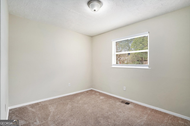 spare room featuring carpet flooring and a textured ceiling