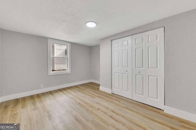 unfurnished bedroom with a closet and light hardwood / wood-style flooring