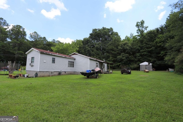 view of yard featuring a storage shed and a trampoline