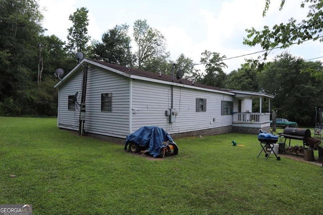 back of property with a lawn and a wooden deck